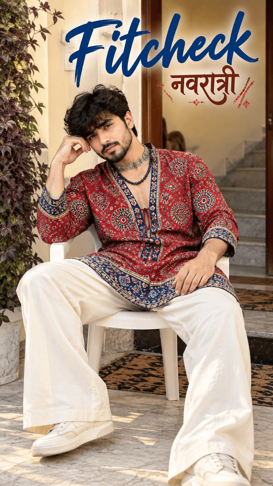 Young man in a red Ajrakh kurta and cream trousers seated on a white chair with festive Navratri text.